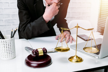 Judge gavel with male lawyer working in background.