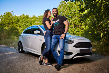 Happy couple with their new modern car