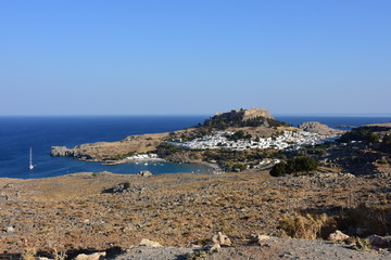 Fototapeta na wymiar Rhodes city view of Lindos and the ancient acropolis and the beautiful blue waters of the Aegean Sea.