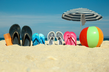 Family slippers on the sand on the beach
