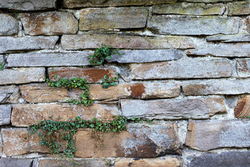 A very old wall made of natural stone, texture of stone.