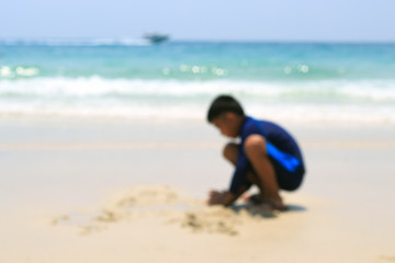A boy playing on the beach sand