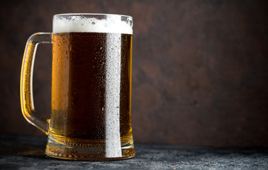 Mug of beer on a dark background with space for inscriptions