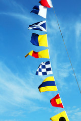 Marine signal flags set against of a blue sky.