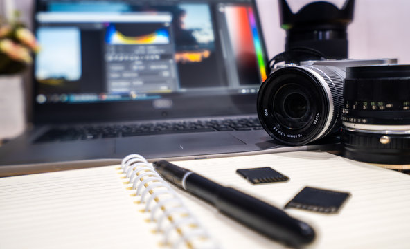 Photographer concept Work space photographer with DSLR camera lense and computer laptop - Powered by Adobe