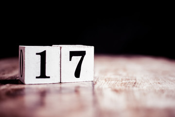 Number 17 isolated on dark background- 3D number seventeen isolated on vintage wooden table - obrazy, fototapety, plakaty