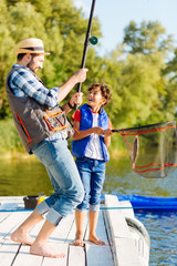 Son feeling excited after catching fish with daddy