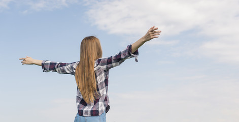 Back view girl enjoying the blue sky