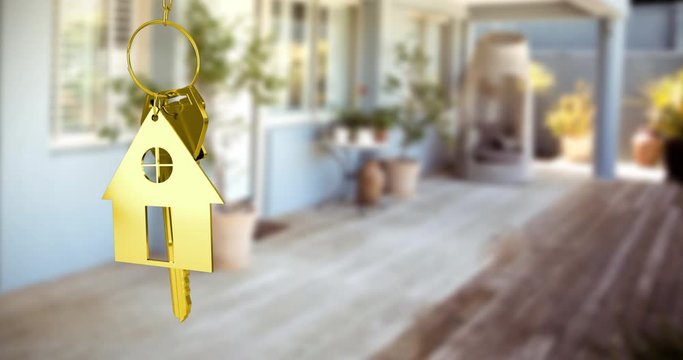 House keys and key fob hanging over out of focus terrace 4k