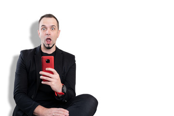 junger Mann schaut erstaunt auf Handy