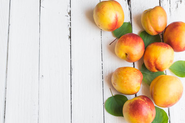 Delicious and juicy peach (nectarina) on white wooden table