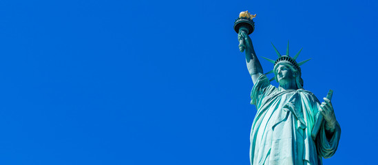Obraz premium Panoramiczny na Statuę Wolności w Nowym Jorku. Statua Wolności z błękitnego nieba nad rzeką hudson na wyspie. Zabytki dolnego Manhattanu w Nowym Jorku.