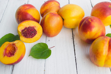 Delicious and juicy peach (nectarina) on white wooden table