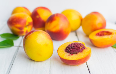 Delicious and juicy peach (nectarina) on white wooden table