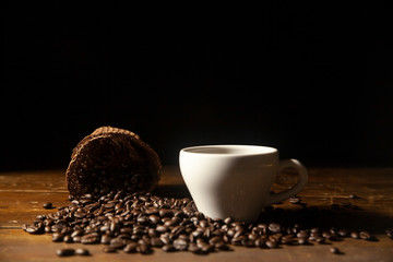 Hot black coffee in cup with coffee bean .