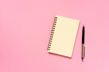 close up top view on blank mockup notebook with pencil on pink color background for design work concept