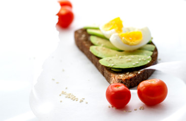 Egg and avocado sandwich.Toast with avocado and egg on rustic wooden background.