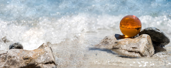 Obraz premium Glass sphere at the beach. Sunny summer day. Abstract photo of summer vacation days.