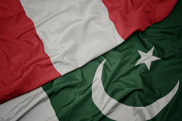 Obraz premium waving colorful flag of pakistan and national flag of peru.