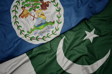 waving colorful flag of pakistan and national flag of belize.