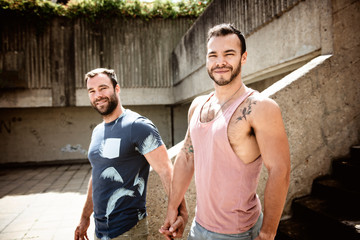 Naklejka na ściany i meble A Portrait of a happy gay couple outdoors in urban background