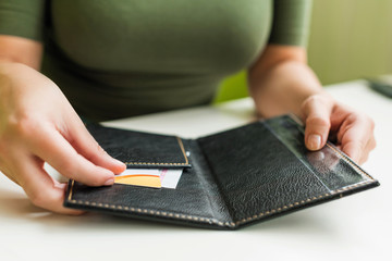Cropped image of  woman hands with folder and bill on the table of cafe. visitor of restaurant ready to pay by credit card