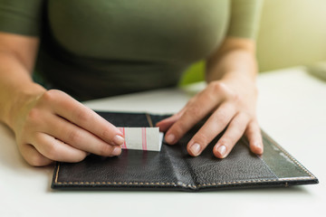 Cropped image of  woman hands with folder and bill on the table of cafe. visitor of restaurant...