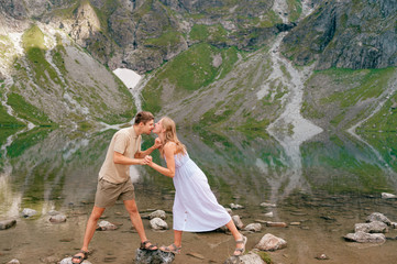Naklejka premium Expressive couple having fun in black lake (Czarny Staw) under Mount Rysy in High Tatra national park.