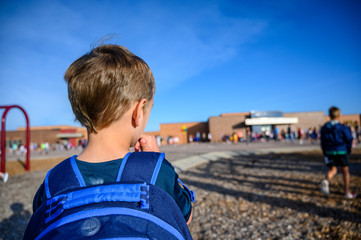 Caucasian boy with back pack on first day of school 