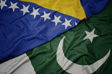 waving colorful flag of pakistan and national flag of bosnia and herzegovina.
