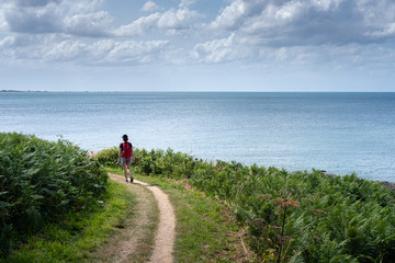 Randonneuse sur un chemin de bord de mer