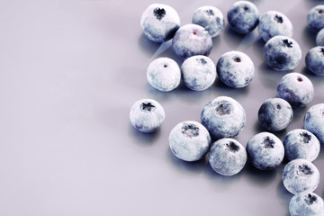 Frozen blueberry berries close-up on a lilac background. Berries in snow.