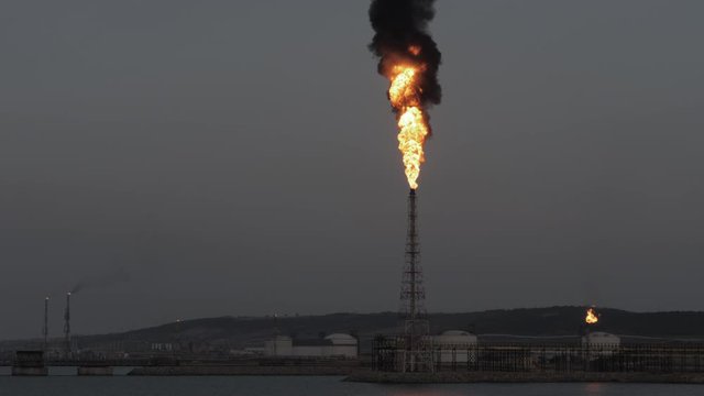 Gas flare and smoke of petrochemical refinery in twilight