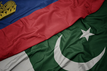 Obraz premium waving colorful flag of pakistan and national flag of liechtenstein.
