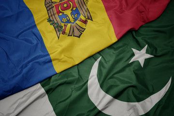 waving colorful flag of pakistan and national flag of moldova.