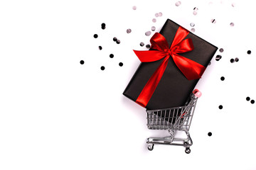 Gift box with red bow in a metal shopping basket with place for text.