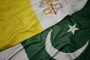waving colorful flag of pakistan and national flag of vatican city.