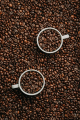 Two cups of fresh roasted coffee beans