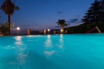 Piscina illuminata al tramonto