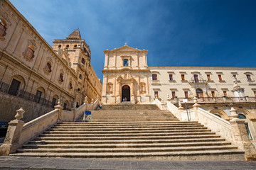Fototapeta premium Scenic entrance stairway and façade of the baroque church of S. Francesco d'Assisi and Monastery of S. Salvatore in Noto, Sicily Italy.