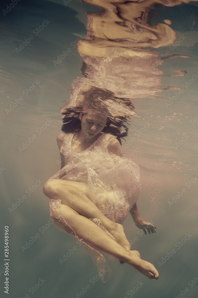 Wall mural portrait of a girl in a dress under water