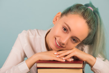 beautiful young woman sits at a table with books