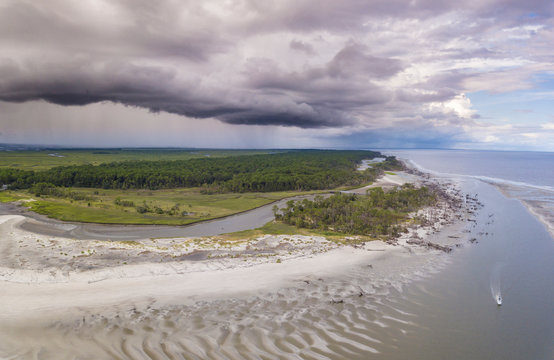 Aerial View Of Boat Passing Island With Approaching Thunderstorm.