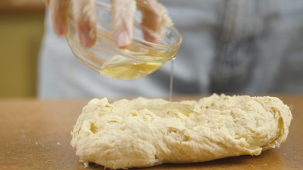 woman mother or daughter on the kitchen table makes domestic food pizza, hands work and pushing stir knead the dough, selective focus dolly shot