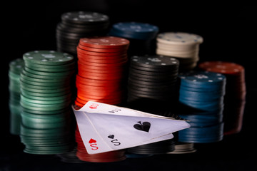 Poker chips with cards on a mirror background