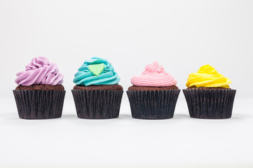 Four Chocolate Cup Cakes With Colorful Icing