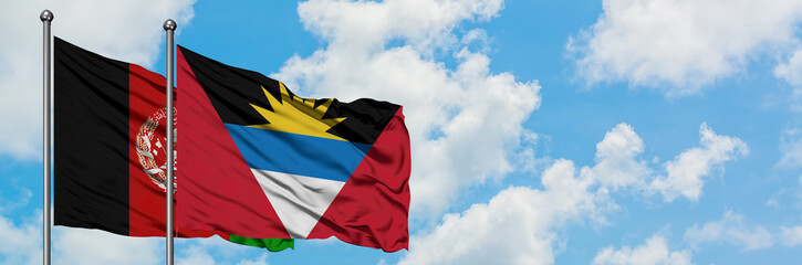Afghanistan and Antigua and Barbuda flag waving in the wind against white cloudy blue sky together. Diplomacy concept, international relations.