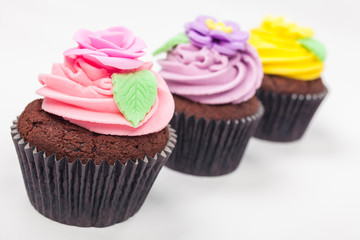 Three Chocolate Cup Cakes With Colorful Icing