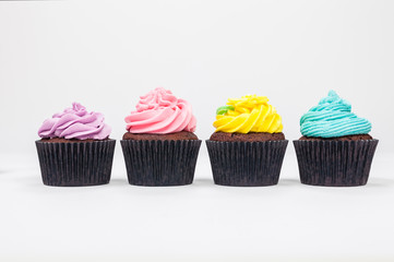 Four Chocolate Cup Cakes With Colorful Icing or Frosting