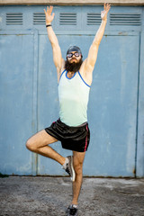 Portrait of a weird, old-fashioned swimmer dressed in 80s style with hat and swimming glasses on the yellow background